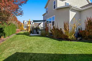 View of green lawn with a patio area