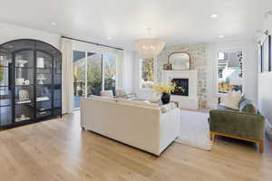 Living area with light wood-style floors, a fireplace, recessed lighting, and a chandelier