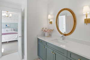 Ensuite bathroom featuring vanity, light colored carpet, and a chandelier