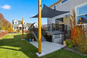 View of green lawn with a patio, stairway, and a deck