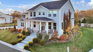 View of front of property featuring a front lawn, a porch, and a shingled roof