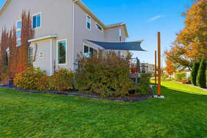 View of side of home with a yard, stucco siding, and a wooden deck