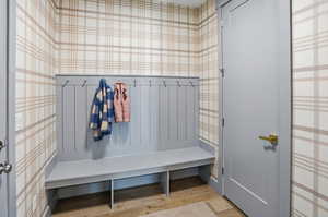 Mudroom with light wood finished floors and wallpapered walls