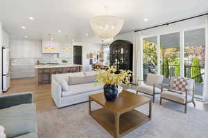 Living area with light wood-style floors, a chandelier, and recessed lighting