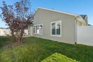 Back of house with stucco siding, a fenced backyard, and a patio area