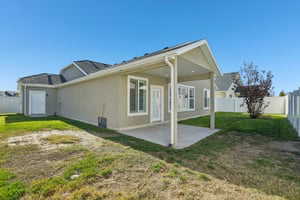 Back of property featuring a fenced backyard, a patio, and stucco siding
