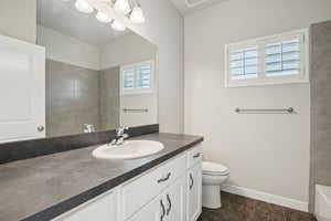 Full bath featuring vanity, dark tile patterned floors, and tub / shower combination
