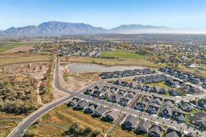 Aerial view of property and surrounding area featuring nearby suburban area and mountains