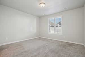 Carpeted spare room with baseboards