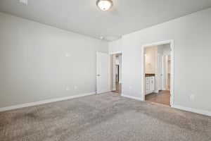 Unfurnished bedroom with carpet floors and ensuite bath