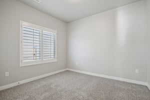 Spare room with baseboards and carpet flooring