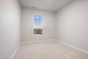 Unfurnished room featuring light carpet and baseboards