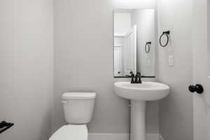 Half bath with toilet and baseboards