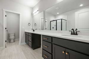 Full bath featuring a stall shower and double vanity