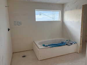 Bathroom featuring a bath and a textured ceiling