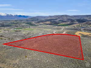 Aerial view of property and surrounding area with property parcel outlined and mountains