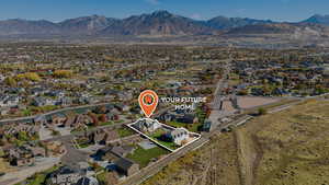 Aerial view of property's location featuring a mountainous background, property boundaries highlighted, and nearby suburban area