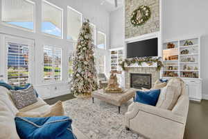 Living area featuring high vaulted ceiling, wood finished floors, and a fireplace
