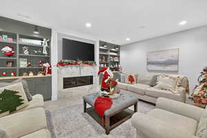 Living area with built in features, a premium fireplace, light carpet, and recessed lighting