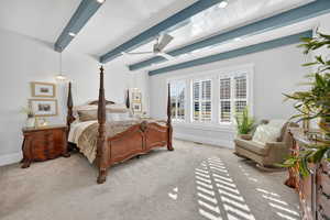 Primary bedroom with beam ceiling and ceiling fan