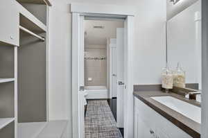 Full bathroom featuring vanity, tub / shower combination, and dark tile patterned floors