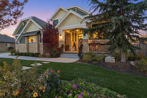 Craftsman house with a front lawn, stone siding, a porch, and a standing seam roof