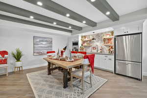 Dining area featuring beam ceiling, light wood-style flooring, and recessed lighting