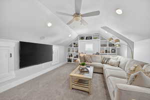 Family room with a textured ceiling, built in shelves, lofted ceiling, recessed lighting, and ceiling fan