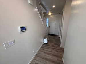 Hall featuring stairs, light wood finished floors, and recessed lighting