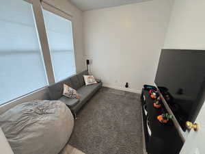 Living area featuring carpet flooring and baseboards