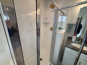 Bathroom featuring a shower stall and vanity