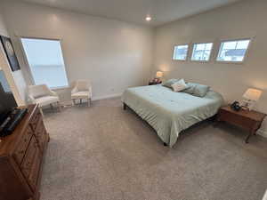 Bedroom with light colored carpet and recessed lighting