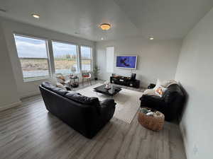 Living area featuring recessed lighting, light wood-style flooring, and a textured ceiling