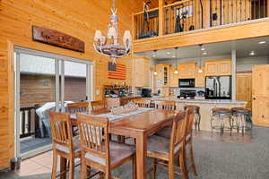 Dining area with wood walls, a towering ceiling, and light tile patterned floors