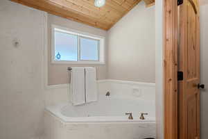 Full bathroom with a bath, lofted ceiling, and wooden ceiling