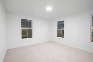 Unfurnished room featuring light carpet
