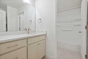 Bathroom with vanity, light tile patterned floors, and shower / bath combination