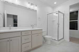 Full bathroom featuring double vanity, a stall shower, light marble finish floors, and recessed lighting