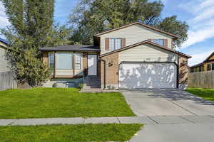 Tri-level home with brick siding, driveway, and an attached garage