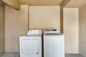 Laundry room with a textured wall and washing machine and dryer