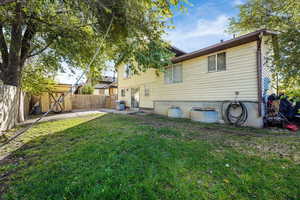 Back of house with a fenced backyard, a patio area, and a shed