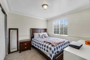 Bedroom with carpet floors and crown molding