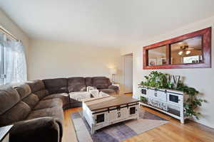 Living room with light wood finished floors and ceiling fan