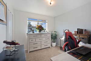 Home office with light carpet and baseboards