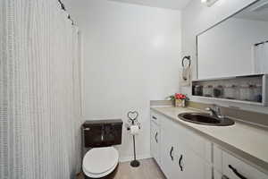 Bathroom with vanity, curtained shower, and light wood finished floors