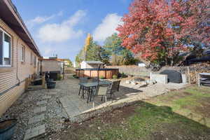 Fenced backyard with a patio, a storage shed, outdoor dining area, and an outdoor fire pit