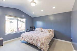 Bedroom with lofted ceiling, recessed lighting, and carpet flooring