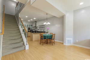 Dining room featuring stairs, recessed lighting, light wood finished floors, and a chandelier