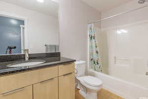 Full bathroom with shower / bath combination with curtain, vanity, and light wood finished floors