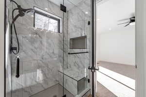 Full bath featuring a marble finish shower and carpet